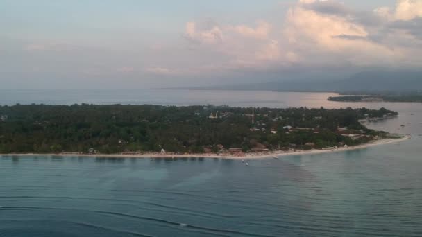 Départ rapide de gili air au coucher du soleil, vous pouvez voir les cafés noyés sous les tropiques et les chaises longues sur la rive et l'île de Lombok en arrière-plan — Video