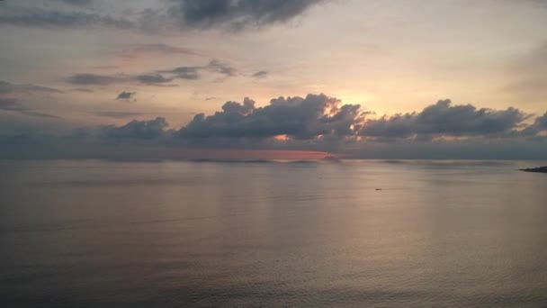 Despegue sobre el océano durante la puesta del sol con flores rosadas y nubes voladoras rápidas — Vídeos de Stock