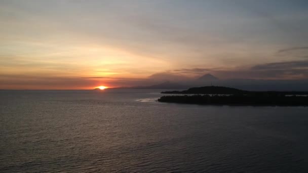 Decolagem contra o fundo de duas ilhas ovais no oceano e contra o fundo visível vulcão Agung ao pôr do sol — Vídeo de Stock