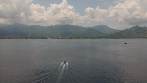 Un grand bateau nage rapidement à travers l'océan vers le rivage avec des montagnes. Lombok — Video