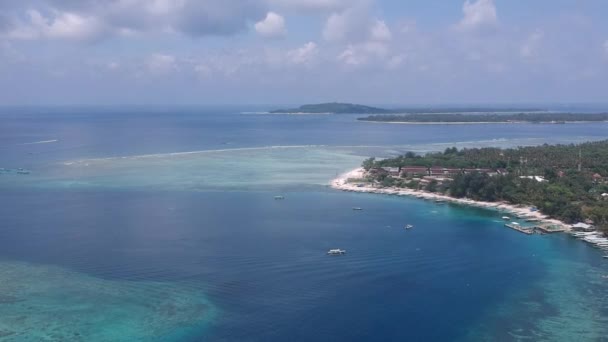 Drohne fliegt bei sonnigem Wetter über die Gili Air Insel vor der Kulisse der Gili Meno Trawangan Inseln — Stockvideo