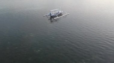 Beyaz ve mavi bir balıkçı teknesine yakın plan, dipten görünen yosun.