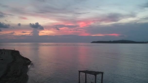 Colorato tramonto rosso su uno sfondo di un'altalena nell'oceano un'isola è visibile — Video Stock