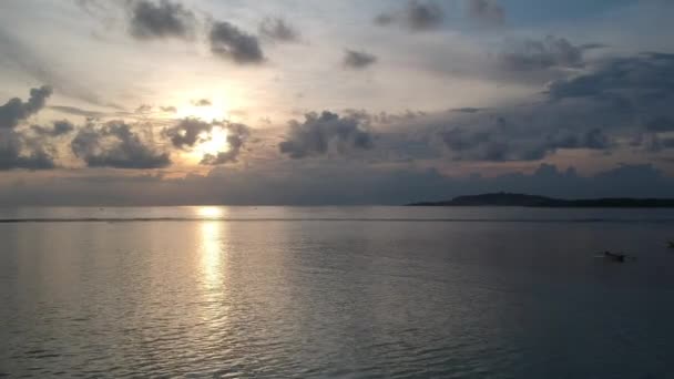 Descolar em um drone para cima durante o pôr do sol nas nuvens ondas visíveis colidindo no meio do oceano — Vídeo de Stock