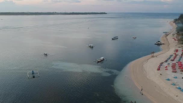 Barcos de pesca en el océano cerca de la isla y la playa con tumbonas — Vídeo de stock