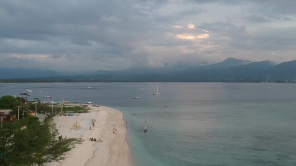 Швидкий прогін уздовж піщаного узбережжя острова з бірюзовою водою видимою яхтою і піщаним пляжем з човнами — стокове відео