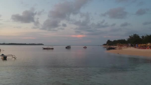 Przelatujące wzdłuż brzegu minione łodzie na tle zachodu słońca gili powietrza — Wideo stockowe