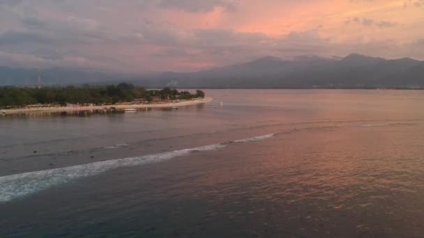 Île avec un coucher de soleil épique vagues visibles s'écrasant loin de la côte Gili air indonesia — Video