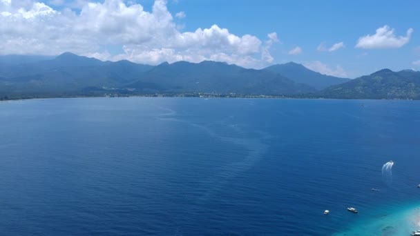 Drone blíží krásný ostrov s horami za slunečného počasí a malé čluny jsou viditelné gili vzduch — Stock video