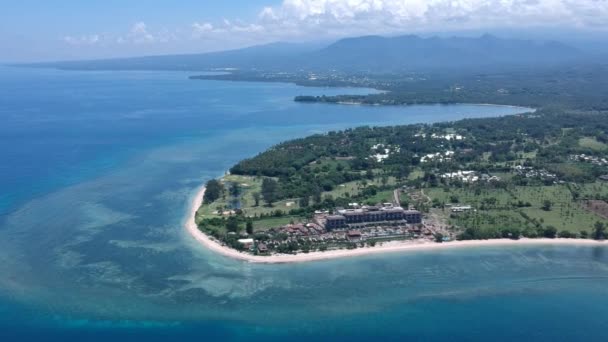 Lombok Adası ve Sira Sahili 'ne insansız hava aracı uçuşu güneşli havada kumsalda büyük bir otel görüyor. — Stok video