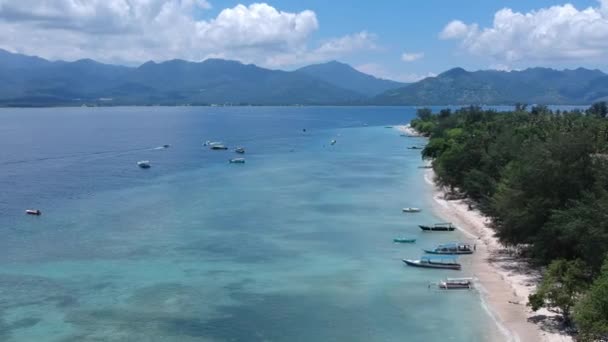 Nedgång ner drönaren över hyllan på den tropiska ön Gili öar och fiskebåtar syns på bakgrunden av ön lombok — Stockvideo