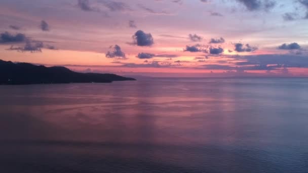 Prachtige zonsondergang boven de oceaan met bergen aan de horizon — Stockvideo