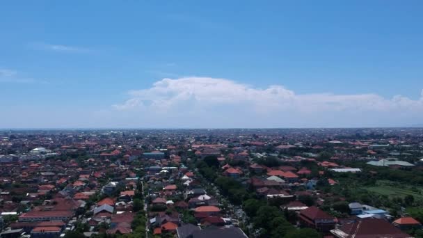 Enjamber une ville avec des bâtiments bas en Asie avec un toit rouge par temps ensoleillé denpasar atherbali ... — Video