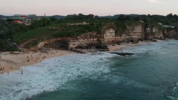 Surfaři jezdit na velkých vlnách proti útesu na pláži Dreamland — Stock video