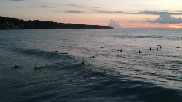Wielu surferów w wodzie o zachodzie słońca Dreamland plaża Bali indonezja — Wideo stockowe