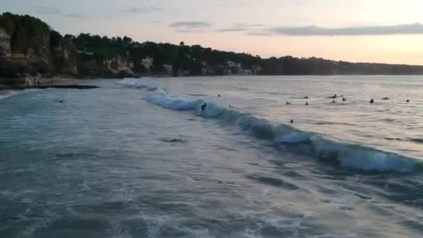 Grandes olas del océano y surfistas Dreamland playa bali indonesia al atardecer — Vídeo de stock