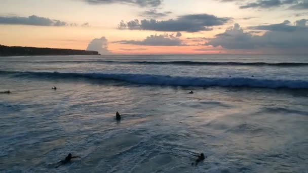 Starten Sie mit einer Drohne von Meereswellen bei Sonnenuntergang mit Surfern Traumstrand — Stockvideo