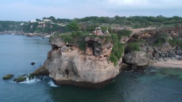 Drone přístup z útesu vyčnívající do oceánu s lidmi bukit bali indonésie — Stock video