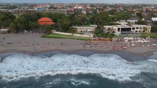 Пляж в Кангу во время заката и люди загорают у воды с большими волнами — стоковое видео