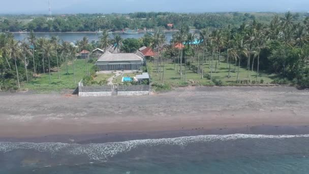 Camera vliegen weg van een zeis tussen een rivier met boten en de oceaan — Stockvideo