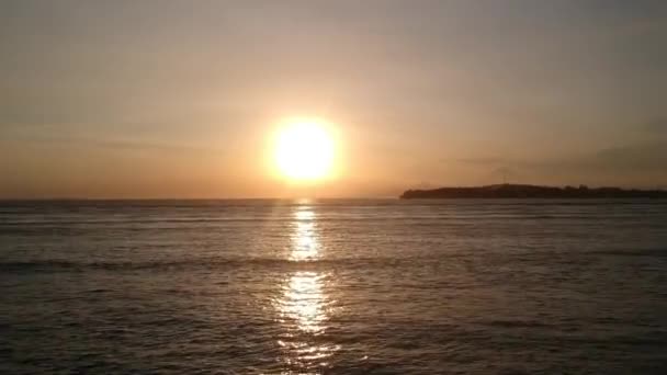 Drone décoller verticalement pendant le coucher du soleil avec un énorme soleil jaune sans nuages gili air — Video