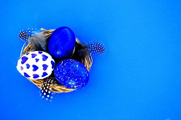 Blauwe Paaseieren Een Nest Met Veren Een Blauwe Achtergrond Kopieerruimte — Stockfoto