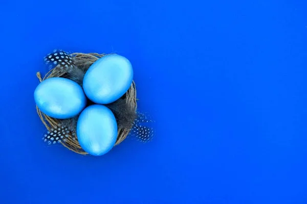 Ovos Páscoa Dourados Ninho Com Penas Fundo Azul Espaço Cópia — Fotografia de Stock