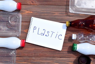 Ahşap arka planda plastik atık. Plastik ve ekolojinin geri dönüşümü kavramı.