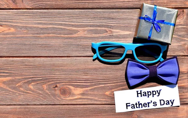 配以蝴蝶结领带 眼镜和礼品盒的木制背景 父亲节快乐 — 图库照片
