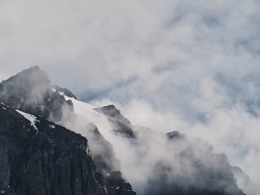 Dağın tepesinde süzülen bulutlar