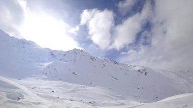 Dağların üzerinden bulutlar uçuyor. Dağlarda güneşli bir gün. Zaman Uygulaması.