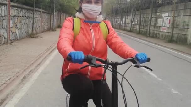 Молода жінка катається на велосипеді з захисною маскою — стокове відео