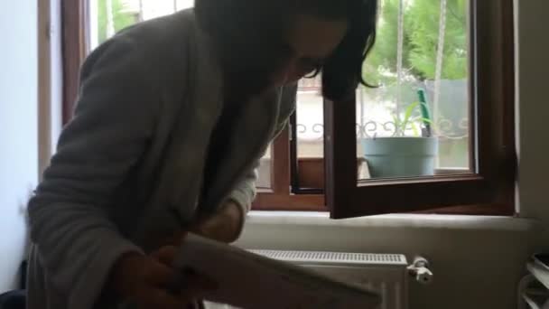 Mujer joven haciendo actividad artística mirando hacia fuera desde la ventana — Vídeo de stock