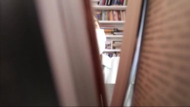 Maskeli genç bir kadın kitap seçiyor.
