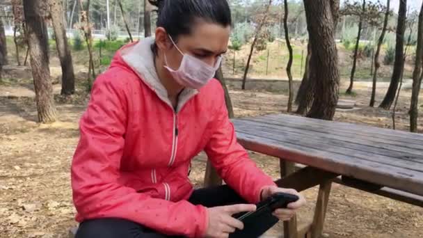 Γυναίκα με ιατρική μάσκα χρησιμοποιώντας smartphone — Αρχείο Βίντεο