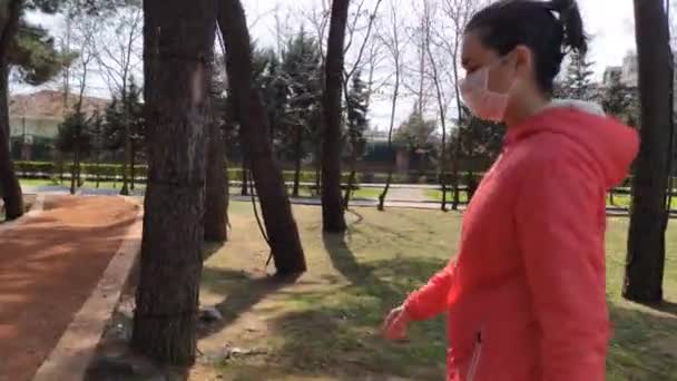 의료용 마스크를 쓴 여성 이 자연 속을 걷고 있습니다 스톡 비디오