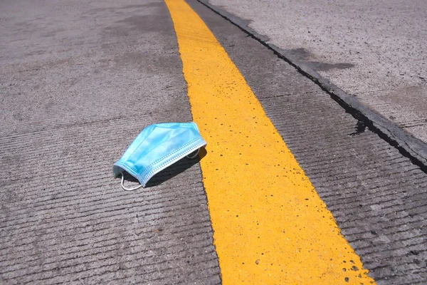 The medical mask is lying on the road