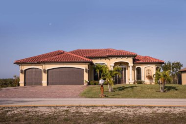 Tipik Southwest Florida beton blok ve palmiye ağaçları, tropik bitkiler ve çiçekler, kırsal kesimde sıva çim çimen ve çam ağaçları. Florida