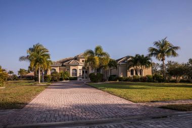 Tipik Southwest Florida beton blok ve palmiye ağaçları, tropik bitkiler ve çiçekler, kırsal kesimde sıva çim çimen ve çam ağaçları. Florida