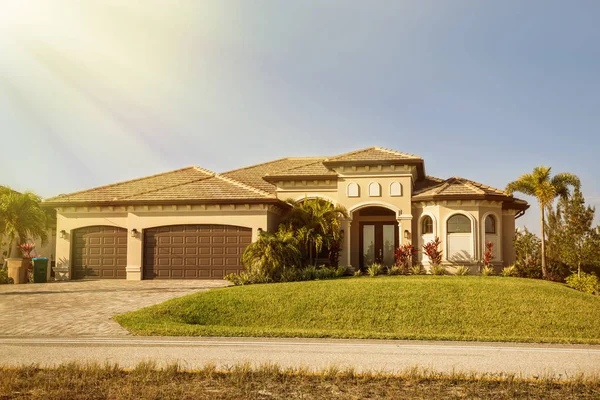 Güney Florida tek müstakil ev güneşli bir gün. Tipik Southwest Florida beton blok ve palmiye ağaçları, tropik bitkiler ve çiçekler, kırsal kesimde sıva çim çimen ve çam ağaçları. Flo