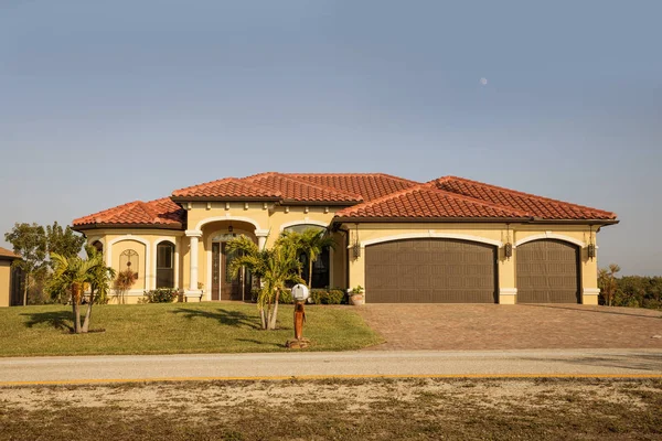 Sur de la Florida casa unifamiliar en un día soleado. Típico bloque de hormigón del suroeste de Florida y casa de estuco en el campo con palmeras, plantas tropicales y flores, césped de hierba y pinos. Flo. — Foto de Stock