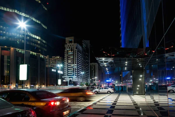 Abu Dhabi - 3 November 2016: Night street i Abu Dhabi, upplysta skyskrapor och bilar på vägarna. Abu Dhabi, Förenade Arabemiraten. — Stockfoto