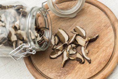 kurutulmuş mantar ahşap bir tepside dökülen bir cam şişe