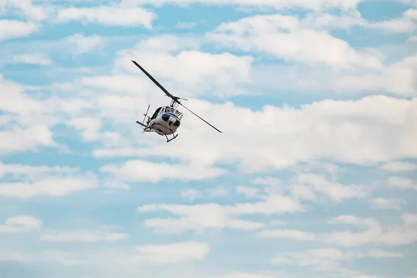 Helicóptero branco voando no céu azul com nuvens — Fotografia de Stock