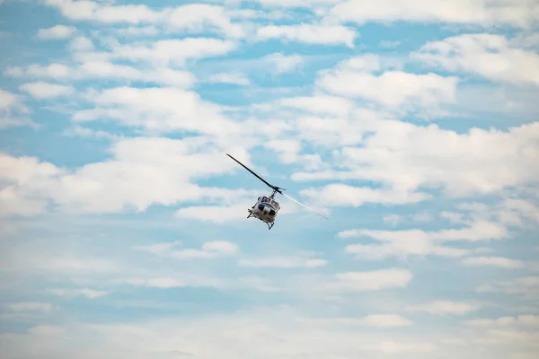 Белый вертолет летит в голубом небе с облаками — стоковое фото
