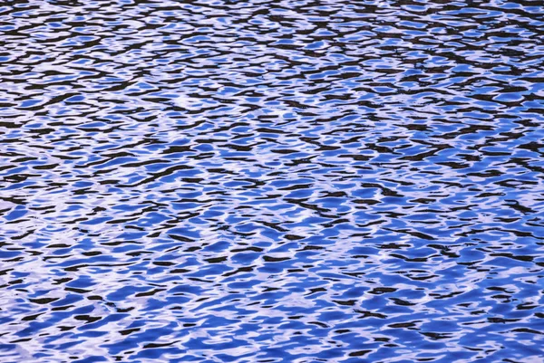 Nível de água, água em movimento. A estrutura refletida do entorno é distorcida pelo movimento da água. Fundo azul abstrato . — Fotografia de Stock