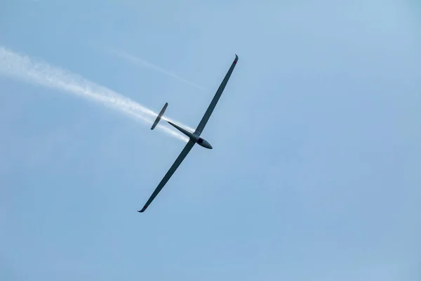 Un planeur volant dans le ciel bleu éjecte l'eau avant l'atterrissage . — Photo