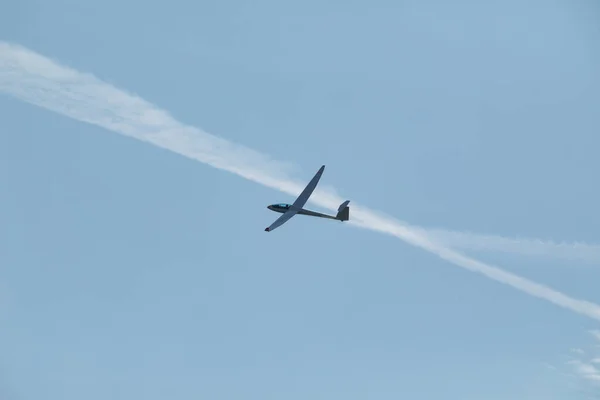 Un planeur volant dans le ciel bleu éjecte l'eau avant l'atterrissage . — Photo