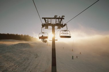 Kış dağlar panorama kayak parkurlarının ve Kayak liftleri, sis ve güneş ışınları ile güneşli gün ile