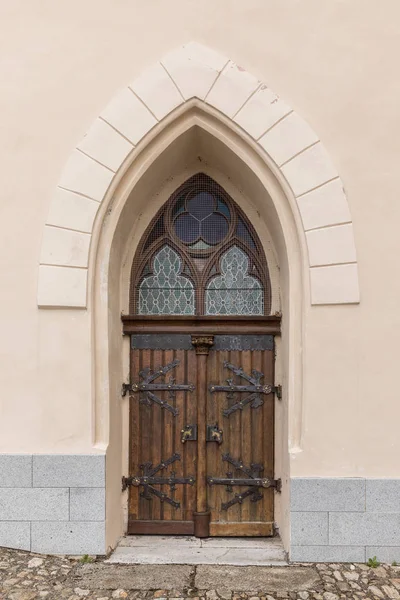 Large wooden door with wrought-iron elements. Decorative door with fittings. — Stock Photo, Image